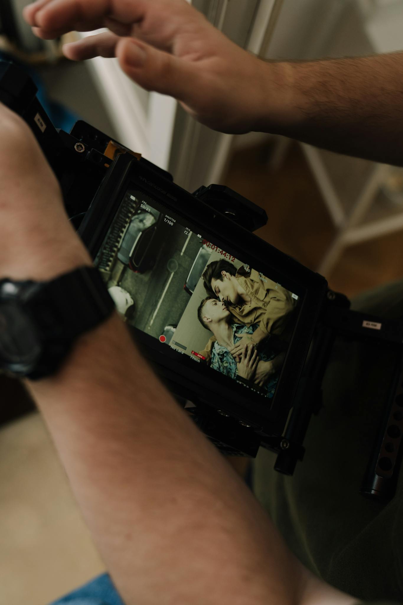 Close-up of a digital camera display showing a couple on a film set, capturing intimate moments.